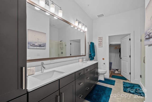 bathroom with a shower with door, vanity, and toilet