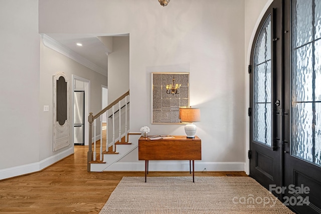 foyer with a wealth of natural light, french doors, a chandelier, and light hardwood / wood-style flooring