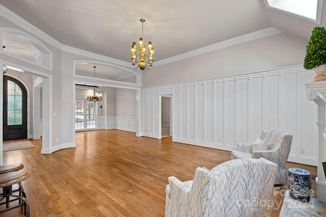 interior space with a healthy amount of sunlight, light hardwood / wood-style floors, ornamental molding, and a chandelier