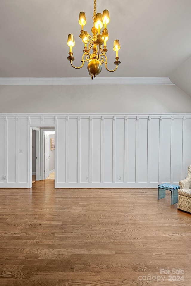 interior space featuring lofted ceiling, an inviting chandelier, light hardwood / wood-style flooring, and crown molding