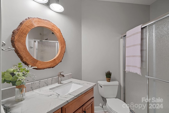 bathroom with vanity, an enclosed shower, and toilet