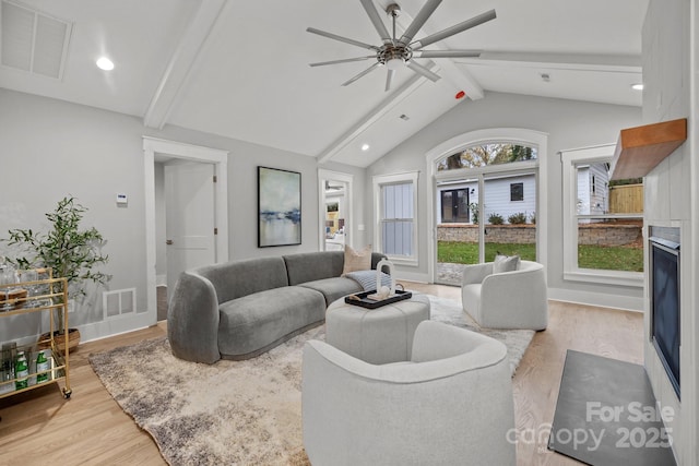 living room with ceiling fan, high vaulted ceiling, light hardwood / wood-style floors, and beamed ceiling