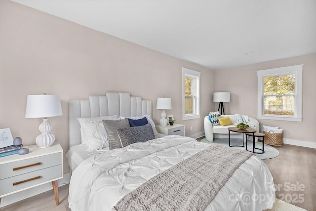 bedroom with multiple windows and light hardwood / wood-style flooring