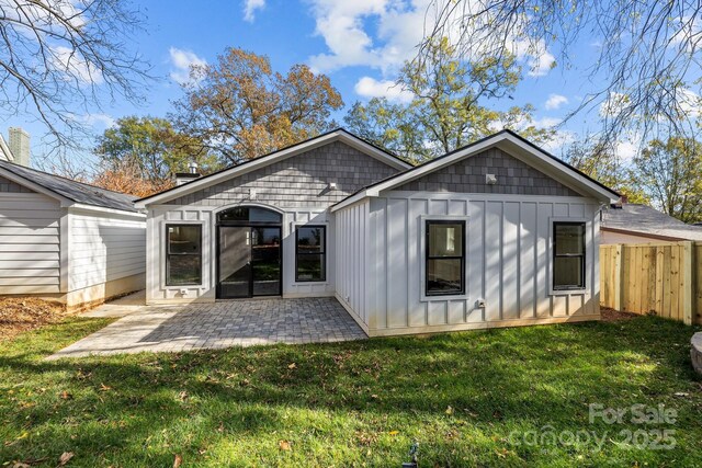 rear view of property featuring a patio area and a lawn