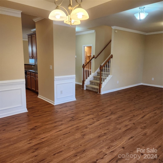 empty room with a chandelier, dark hardwood / wood-style flooring, and crown molding