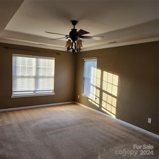 empty room with plenty of natural light, light colored carpet, and ornamental molding