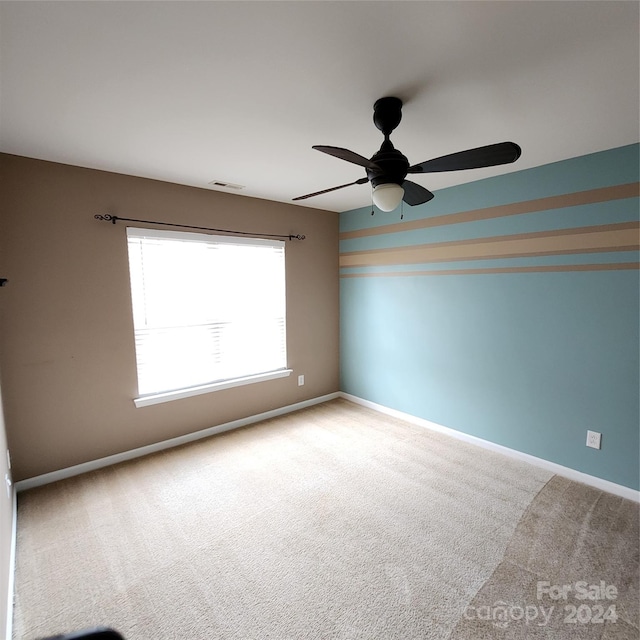 empty room with ceiling fan and carpet floors