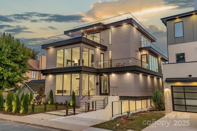 contemporary home featuring a balcony and a garage