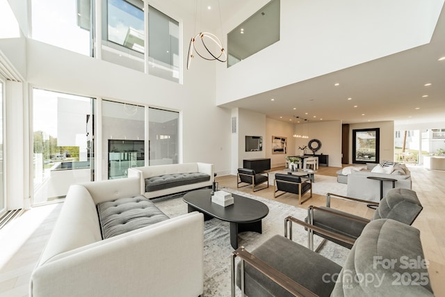 living room with a high ceiling and light hardwood / wood-style floors