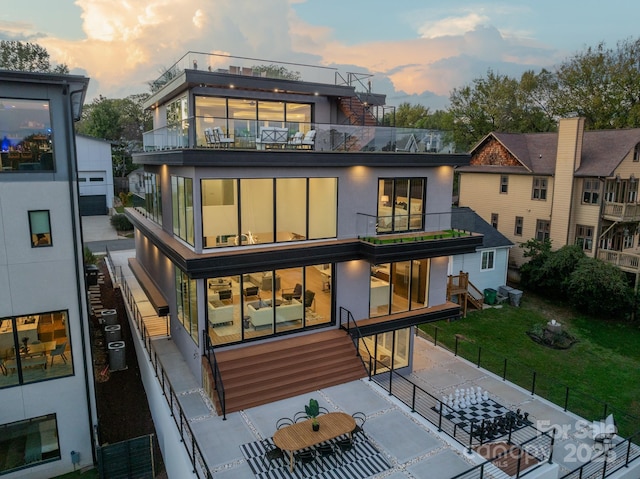 back house at dusk featuring a balcony