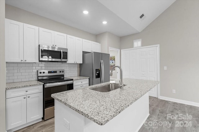 kitchen featuring white cabinets, appliances with stainless steel finishes, a center island with sink, and sink