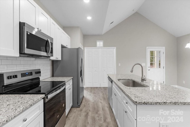 kitchen with white cabinets, sink, stainless steel appliances, and a kitchen island with sink