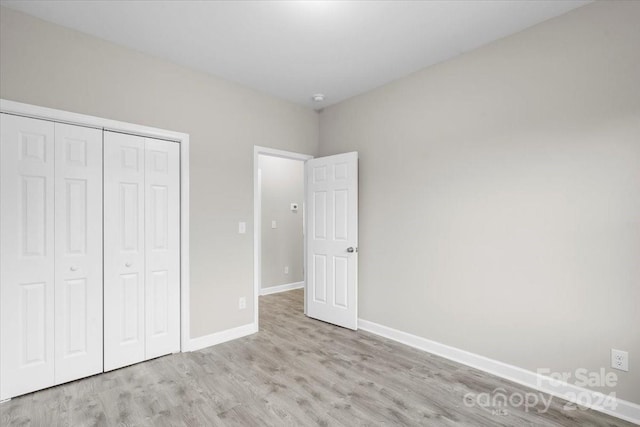 unfurnished bedroom featuring light hardwood / wood-style floors and a closet