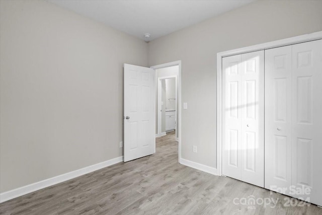 unfurnished bedroom with light hardwood / wood-style flooring and a closet