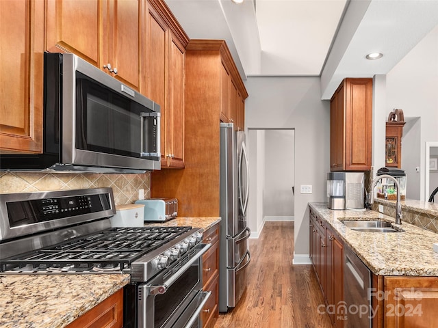 kitchen featuring sink, appliances with stainless steel finishes, light wood-type flooring, and light stone countertops