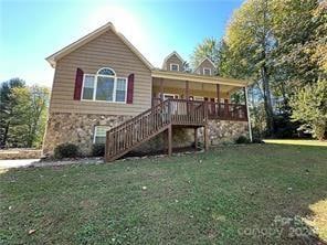 rear view of property featuring a deck and a yard