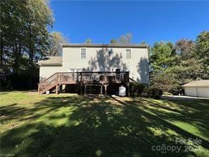 rear view of property with a wooden deck and a lawn