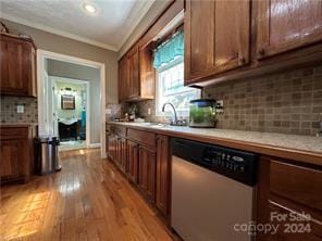 kitchen with light wood-type flooring, tasteful backsplash, ornamental molding, sink, and dishwasher