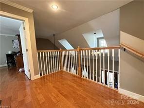 additional living space with hardwood / wood-style flooring and lofted ceiling with skylight