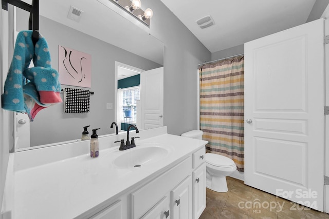 bathroom with vanity, toilet, and tile patterned floors