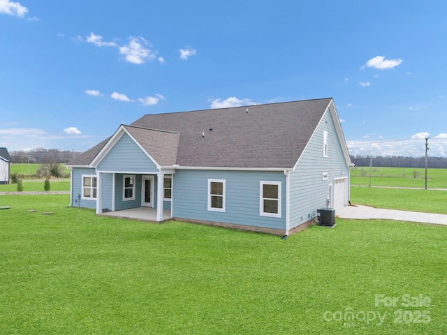 back of house featuring a yard, a garage, and central AC unit