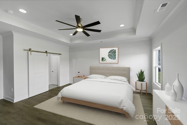 bedroom featuring crown molding, ceiling fan, a barn door, dark hardwood / wood-style flooring, and a raised ceiling