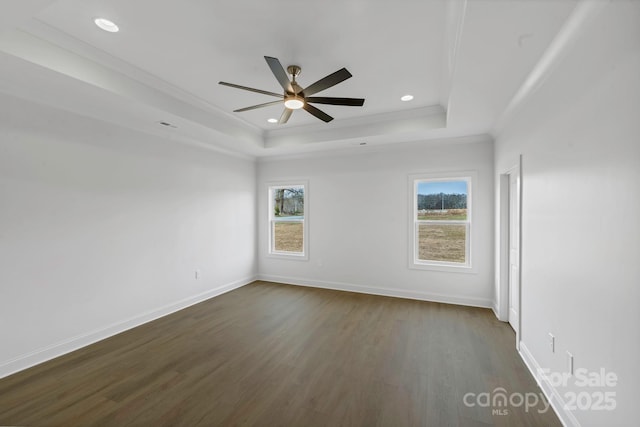 spare room featuring ornamental molding, dark wood-type flooring, ceiling fan, and a tray ceiling