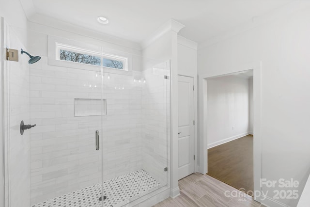 bathroom with ornamental molding and a shower with door