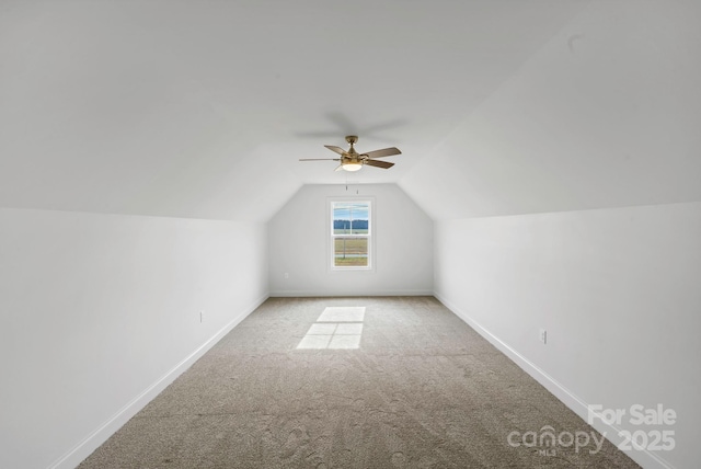 additional living space with vaulted ceiling, carpet flooring, and ceiling fan