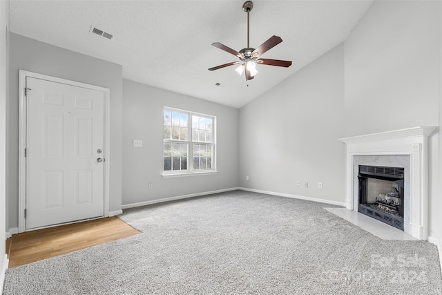 unfurnished living room with light carpet, a fireplace, ceiling fan, and high vaulted ceiling