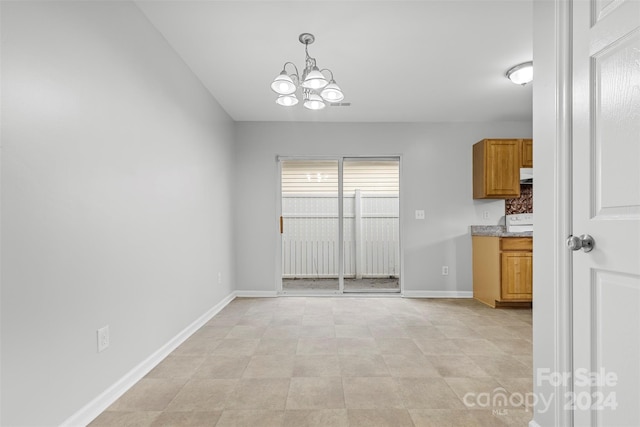 unfurnished dining area featuring a notable chandelier and light tile patterned flooring