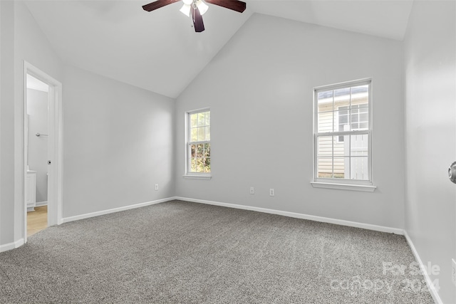 empty room with carpet flooring, ceiling fan, high vaulted ceiling, and a healthy amount of sunlight