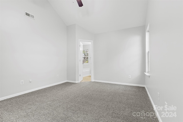 carpeted spare room with ceiling fan and vaulted ceiling