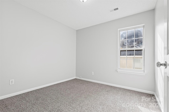 carpeted spare room featuring a textured ceiling