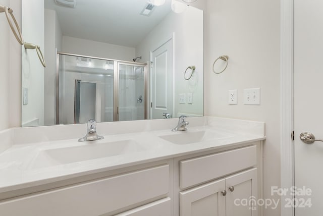 bathroom featuring vanity and an enclosed shower