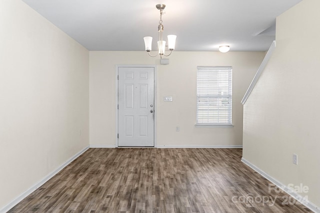 interior space featuring dark wood-type flooring and a notable chandelier