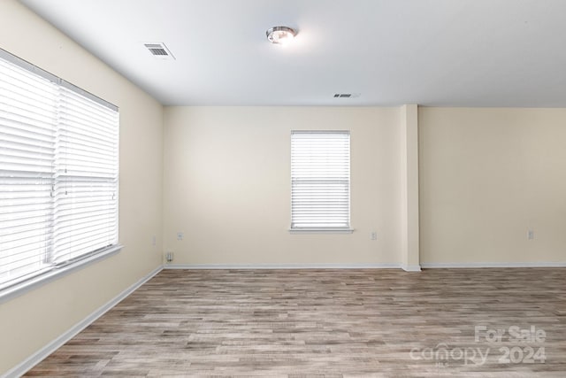 empty room with light hardwood / wood-style flooring and a healthy amount of sunlight