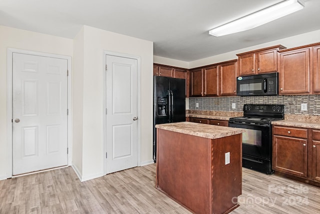 kitchen with black appliances, decorative backsplash, a kitchen island, and light wood-type flooring