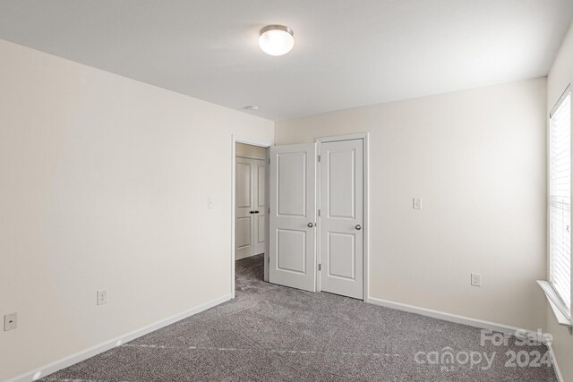 unfurnished bedroom featuring a closet and carpet floors