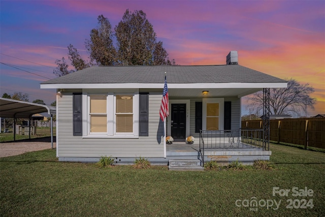 view of front of property featuring a carport, a porch, and a lawn