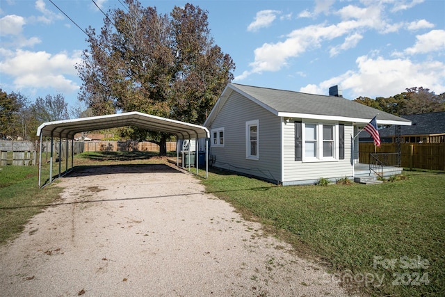 view of side of home with a carport and a lawn