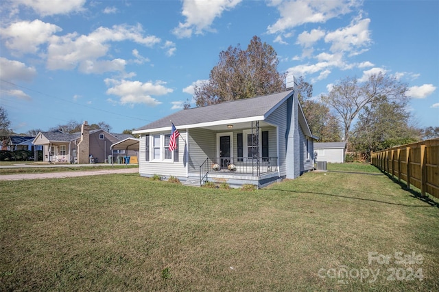 view of front of property featuring a front yard, cooling unit, a porch, and a carport