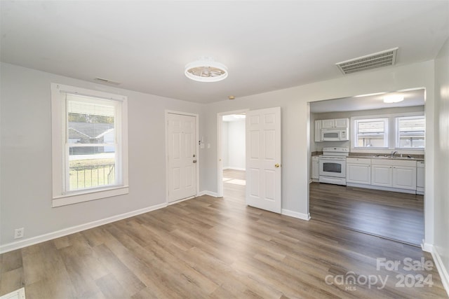 unfurnished living room featuring sink and light wood-type flooring