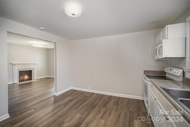 kitchen featuring dark hardwood / wood-style flooring, a brick fireplace, white appliances, sink, and white cabinets