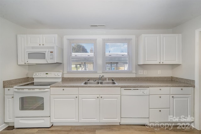 kitchen with white cabinetry, white appliances, and sink