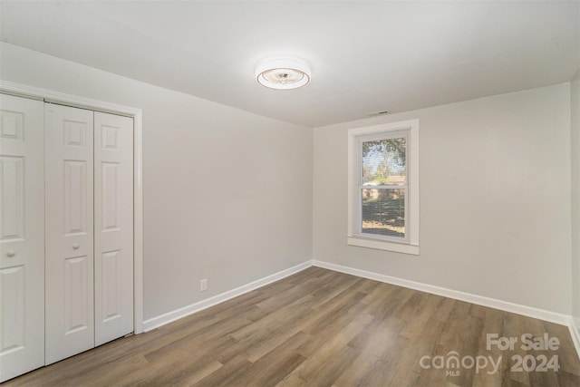 unfurnished bedroom featuring a closet and wood-type flooring