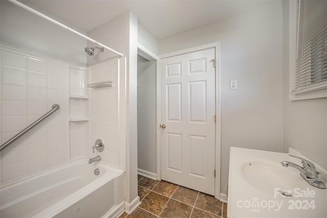 bathroom with tile patterned flooring, tiled shower / bath combo, and sink