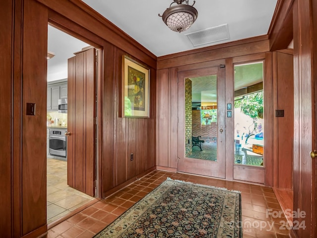 entryway with wood walls