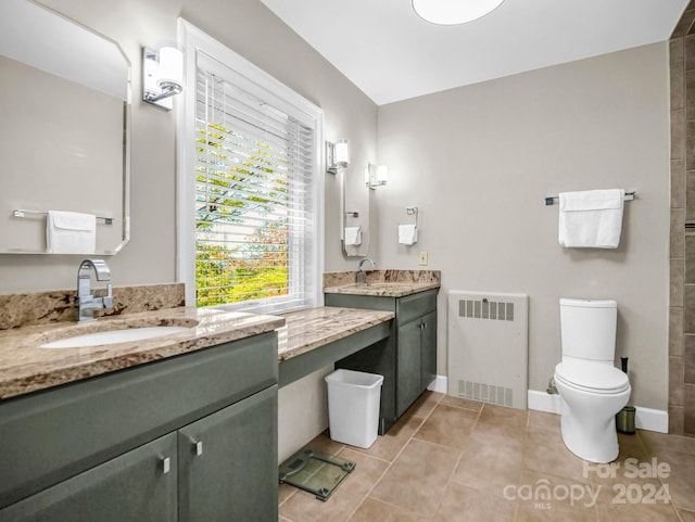 bathroom featuring tile patterned flooring, radiator heating unit, vanity, and toilet