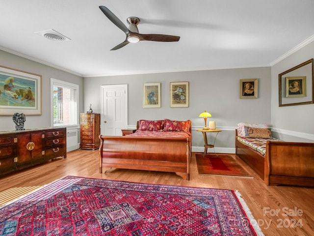 bedroom with ceiling fan, light hardwood / wood-style floors, ornamental molding, and radiator